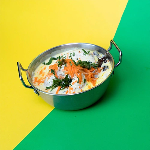 Crispy South Indian vada soaked in yogurt, served with chutney and sambar